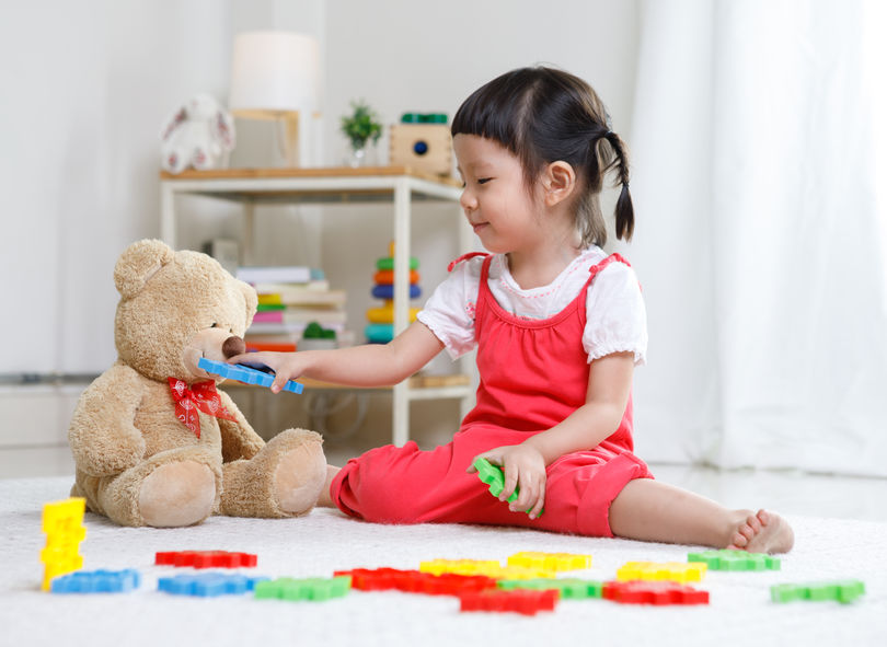 little girl playing with teddy bear